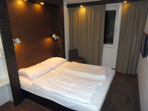 B&B Hotel Offenbach, Offenbach, Deutschland, Zimmer 225 mit Doppelbett, Leuchten, Stuhl, Fenster und lichtdichten Gardinen