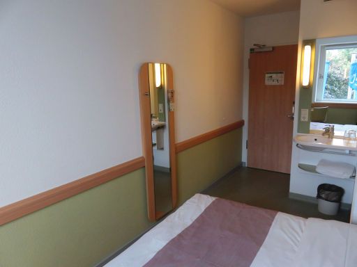 ibis budget Berlin Alexanderplatz, Berlin, Deutschland, Zimmer 221 mit Wandspiegel, Eingangstür, Waschbecken und Trennwand zur Dusche