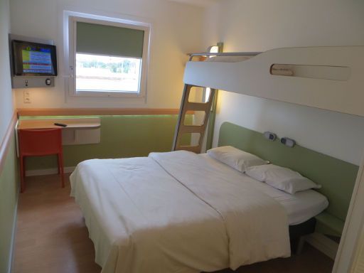 ibis budget Hotel München Airport Erding, Deutschland, Zimmer 228 mit Flachbildfernseher, Fenster, Stuhl, Tisch, Etagenbett und Doppelbett