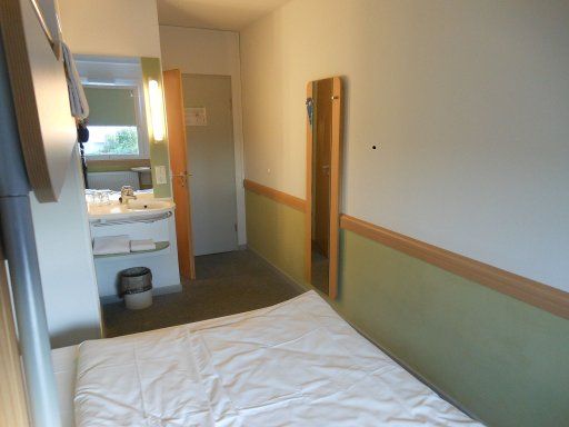 ibis budget Würzburg Ost, Deutschland, Zimmer 304 mit Waschtisch, Doppelbett, Wandspiegel, Tür zum WC und Eingangstür