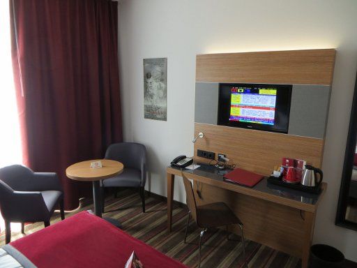 Leonardo Hotel, Völklingen, Deutschland, Zimmer 110 mit Tisch, zwei Stühlen, Schreibtisch, Stuhl, Flachbildfernseher und Wasserkocher