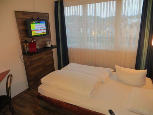 Mercure Hotel Bensheim (geschlossen), Deutschland, Zimmer 415 mit Doppelbett, Nachttischleuchten, Fernseher, Kaffeemaschine, Wasser und Fenster