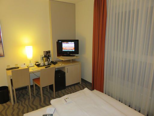 Mercure Hotel Hannover Mitte, Hannover, Deutschland, Zimmer 542 mit Fenster, Schreibtisch, Stuhl, Flachbildfernseher, Wasserkocher, Kühlschrank und Minisafe