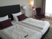 Mercure Hotel Hannover Oldenburger Allee, Hannover, Deutschland, Zimmer 626 mit zwei verbundenen Einzelbetten, Nachttischleuchte, Seseel, Tisch und Fenster