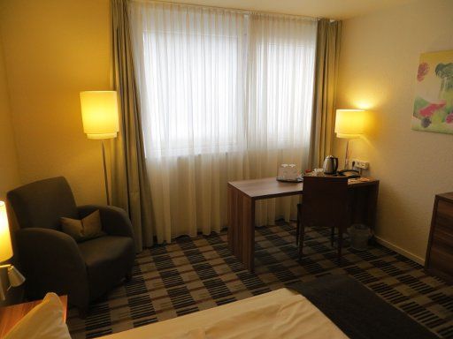 Mercure Hotel Saarbrücken Süd, Deutschland, Zimmer 230 mit Sessel, Fenster, Schreibtisch und Wasserkocher
