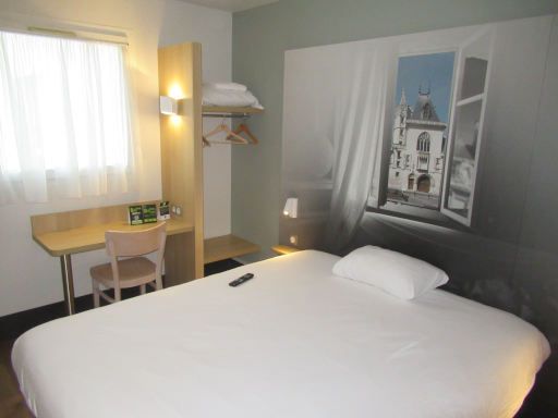 B&B Hotel Bourges 2, Bourges, Frankreich, Zimmer 007 mit gro&szlig;em Bett, Leseleuchten, Nachttisch, Garderobe, Tisch, Stuhl und  Fenster