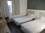 B&B Hotel Brumath Bernolsheim, Bernolsheim, Frankreich, Zimmer 207 mit zwei Betten, Leseleuchten, Fenster, Tisch, Stuhl und Kofferablage