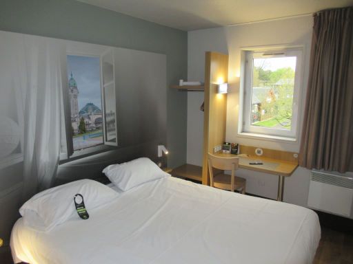 B&B Hotel Limoges 1, Limoges, Frankreich, Zimmer 222 mit gro&szlig;em Bett, Leseleuchten, Nachttisch, Garderobe, Tisch, Stuhl, Fenster und Heizk&ouml;rper