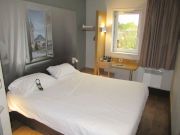 B&B Hotel Limoges 1, Limoges, Frankreich, Zimmer 222 mit gro&szlig;em Bett, Leseleuchten, Nachttisch, Garderobe, Tisch, Stuhl, Fenster und Heizk&ouml;rper