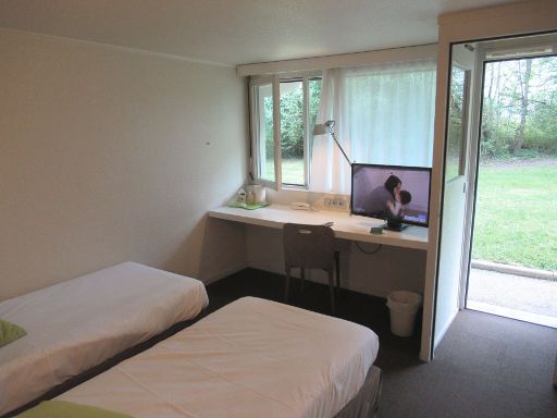 Campanile Auxerre - Monéteau, Frankreich, Zimmer 018 mit Tisch, Stuhl, Büroleuchte, Flachbildfernseher, Fenster und Eingangstür