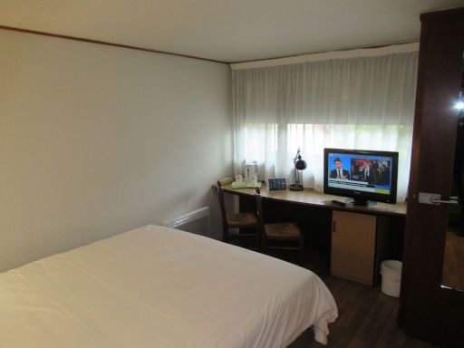 Campanile Maubeuge, Maubeuge, Frankreich, Zimmer 12 mit Tisch, Stuhl, Wasserkocher, Flachbildfernseher, Fenster und Eingangstür