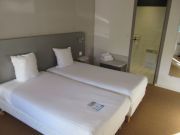KYRIAD DIRECT AUXERRE - APPOIGNY, Appoigny, Frankreich, Zimmer 422 mit zwei Betten, Nachttisch, Leseleuchte und T&uuml;r zum Badezimmer