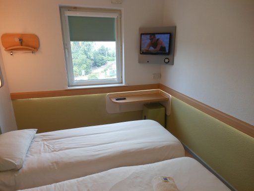 ibis budget Leeds Centre, Leeds, Großbritannien, Zimmer 603 mit Flachbildfernseher, Ecktisch, Hocker und Fenster mit Verdunklungsrollo