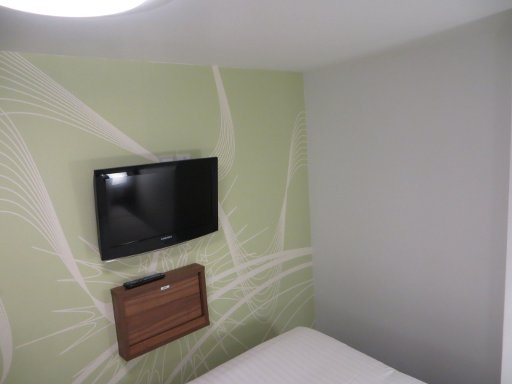 Tune Hotel Liverpool Street, London, Großbritannien, Zimmer 19 mit Flachbildfernseher, ausklappbaren Tische und LED Deckenleuchte