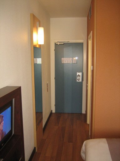 Ibis Verona, Italien, Zimmer 225 mit Wandspiegel, Eingangstür und Tür zum Bad