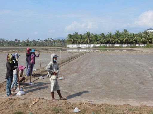 Kampot, Kambodscha, Captain Chim’s Grand Kampot Tour, Arbeiter bereiten ein Feld zur Salzgewinnung vor