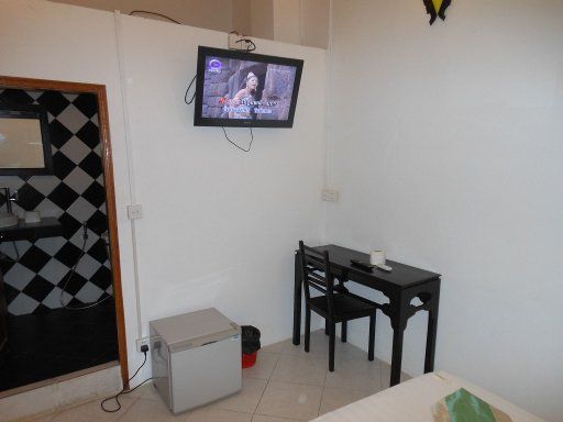 Sary’s Guesthouse, Phnom Penh, Kambodscha, Zimmer Friday mit Fernseher, Kühlschrank, Eingang zum Bad, Schreibtisch und Stuhl