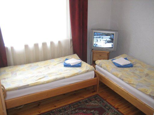 Hotel Multilux Riga, Lettland, Zimmer 24–2 mit zwei Einzelbetten, Fernseher, kleinem Schrank und Fenster