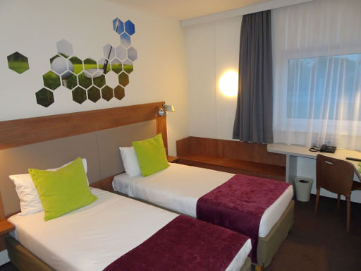 ibis Styles Vilnius, Vilnius, Litauen, Zimmer 203 mit zwei Einzelbetten, Leseleuchten, Kofferablage, Tisch, Stuhl, Fenster und Wasserkocher