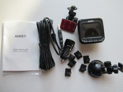 AUKEY DR01 Dashcam, Lieferumfang mit Halterungen für Kabel, Saugnapfhalterung, Halterung mit Klebefläche, Dashcam, Bedienungsanleitung, Zigarettenanzünder USB Adapter und Verbindungskabel