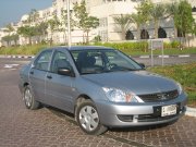 Dollar Rent A Car, Dubai, Mitsubishi Lancer GL 1300 Benziner im Dezember 2010, Ansicht von der Seite / vorne