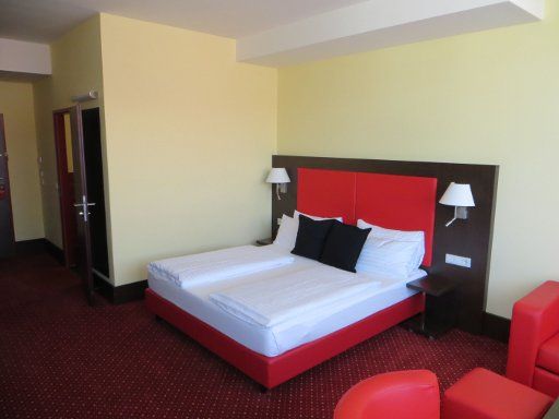 AMEDIA Hotel, Salzburg, Österreich, Zimmer 409 mit Doppelbett, zwei Nachttischleuchten, Leseleuchten, Trennwand zum Bad und Sitzgruppe