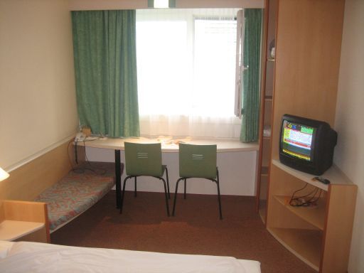 Ibis Salzburg Nord, Salzburg, Österreich, Sitzbank / Kofferablage, Tisch mit 2 Stühlen, Fernseher und Fenster