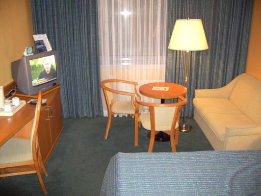 Holiday Inn Hotel Warschau, Warschau, Polen, Schreibtisch mit Stuhl, Fernseher, Tisch mit zwei Stühlen und Sofa