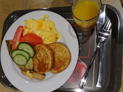 Ibis Wrocław Centrum, Breslau, Polen, Auswahl vom Frühstücksbuffet Rühreier, Pancakes, Würstchen, Pfannkuchen, Tomaten und Gurken