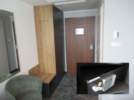 Kyriad Stargard, Pommern, Polen, Zimmer 414 mit Sessel, Kofferablage, Schrank mit Minisafe, Eingangstür, Klimaanlage und Tür zum Bad
