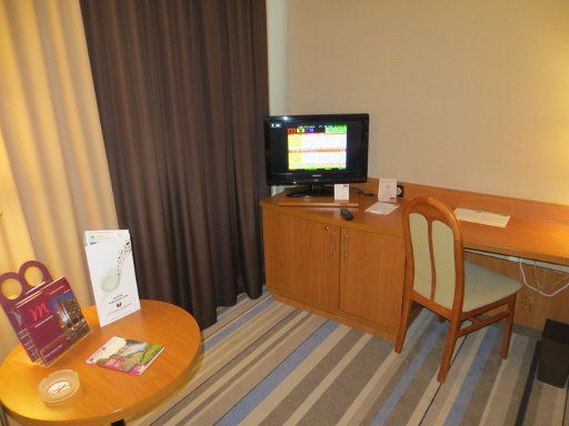 Mercure Warszawa Centrum, Warschau, Polen, Zimmer 343, Schreibtisch, Fernseher, Minibar und mehrfarbige Gardinen