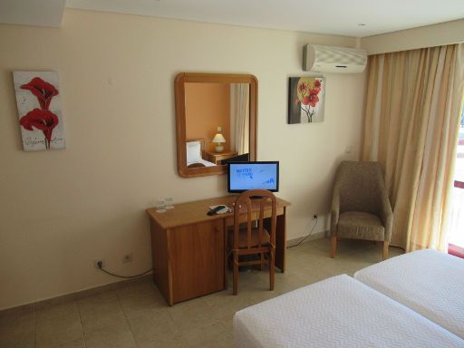 Hotel Alba, Monte Gordo, Portugal, Zimmer 203 mit Tisch, Kühlschrank, Stuhl, Spiegel, Fernseher Klimaanlage, Sessel und Balkontür