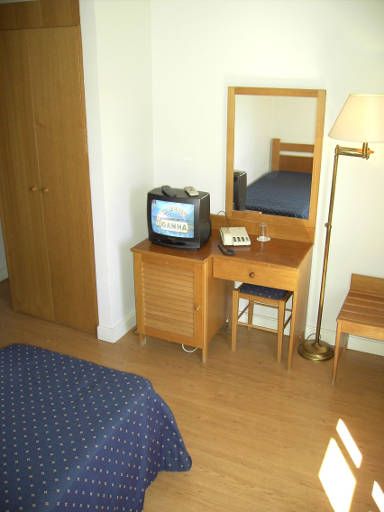 Hotel Afrin Lisboa (ehemals Hotel Residencial Estoril Lissabon), Portugal, Einzelzimmer mit Schrank, TV, Tisch, Hocker und Kofferablage