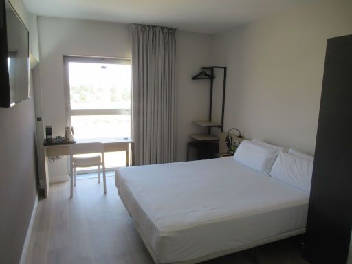 B&B Hotel Granada, Granada, Spanien, Doppelzimmer 303 mit gro&szlig;em Bett, Schreibtisch mit Wasserkocher und Kaffeekapselmaschine, Fenster, Gardine, offener Schrank, Leseleuchten und Nachttisch