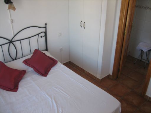 Hostal La Paloma II, Calpe, Spanien, Bett mit Tageskopfkissen, Wandschrank und Eingang zum Bad