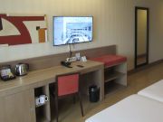 Hotel Ibersol Atrio del Mar, Los Alc&aacute;zares, Spanien, Zimmer 301 mit Flachbildfernseher, lautlosen K&uuml;hlschrank, Wasserkocher, Kaffeemaschine, Tisch, Stuhl, Wandspiegel, Klimanlage, Durchgang zum Bad und Eingangst&uuml;r