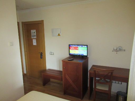 Hotel Meleiros, Castro de Sanabria, Spanien, Zimmer 126 mit Einbauschrank, Tür, Kofferablage, Flachbildfernseher, Kühlschrank, Tisch mit Leseleuchte und Stuhl