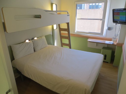 ibis budget Madrid Valentin Beato, Spanien, Zimmer 314 mit Doppelbett, Kinderbett, Fenster, Stuhl, Tisch und Fernseher