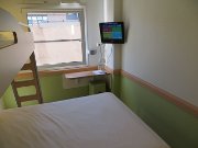 ibis budget Madrid Valentin Beato, Spanien, Zimmer 314 mit Queen Size Bett, Kinderbett, Fenster, Stuhl, Tisch und Fernseher