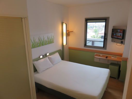 ibis budget Sevilla, Spanien, Zimmer 522 mit Doppelbett, Fenster, Stuhl, Tisch, Kofferablage, Fernseher