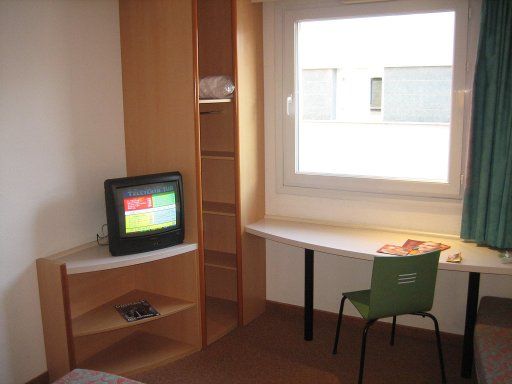 Ibis Granada, Spanien, Fenster, offener Schrank, Fernseher, offener Eckschrank, Fenster, Tisch und Stuhl