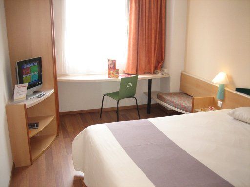 Ibis Sevilla, Spanien, Zimmer 19 mit Doppelbett, Fenster, Stuhl, Tisch, Kofferablage, Fernseher