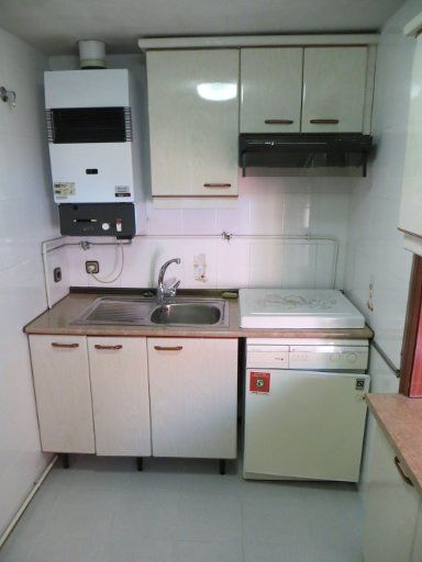 redpiso Servicios Inmobiliarios, Madrid, Spanien, Calle de Virgen de Lluc 81, Küche mit Gas Kombitherme, Schränken, Spüle und defekter Waschmaschine