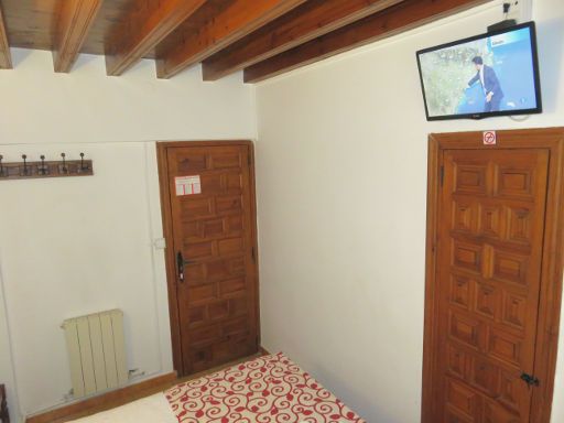 Posada San Julián, Cuenca, Spanien, Zimmer 11 mit Holzdecke, Garderobe, Eingangstür und Flachbildfernseher