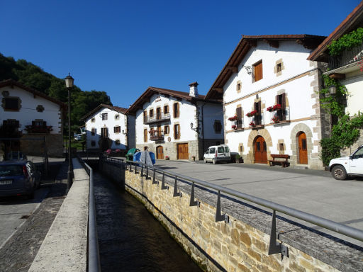 Auza, Navarra, Spanien, Ortskern mit Bach und großen Häusern