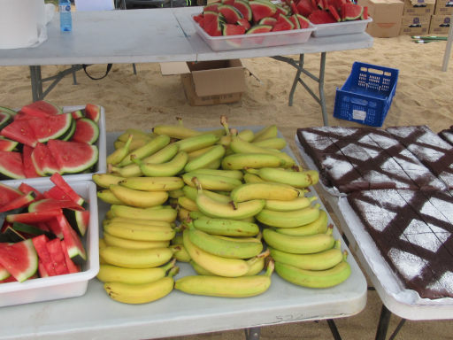 V. Travessia Les Platges de Lloret, Schwimmwettbewerb 2025, Lloret de Mar, Spanien, Auswahl an Wassermelonen, Bananen und Schokoladenkuchen