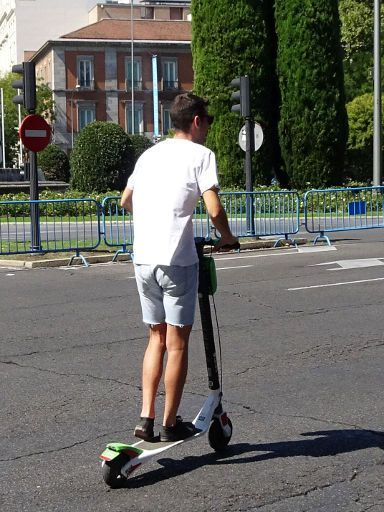 Lime, Elektroroller Sharing, Madrid, Spanien, Fahrt ohne Helm auf der Straße