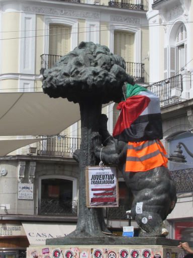 Proteste Wohnungsrecht Plaza Puerta del Sol 2026, Madrid, Spanien, Statute B&auml;r mit Pal&auml;stina Flagge und Warnweste