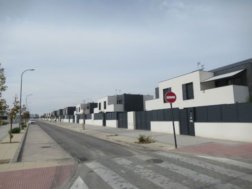 Stadtteil El Monte de la Villa, Villaviciosa de Odón, Spanien, Reihenhäuser mit Mauern und Zäunen in einer Einbahnstraße