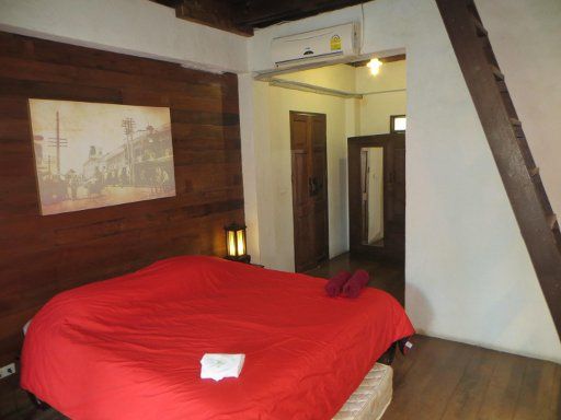 Baan Gong Kham, Chiang Mai, Thailand, Zimmer 304 mit Doppelbett, Eingangstür, Schrank, Trennwand zum Bad und Holztreppe zum Boden